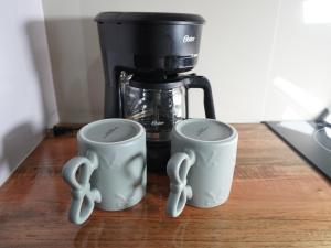 two mugs with handles are sitting on a table at Pequeño Refugio in Ticul +21 photos