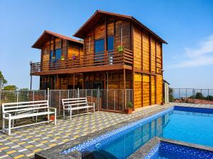 a house with a swimming pool in front of a house at Royal Shouryas Resort in Kolhapur