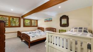 a bedroom with two beds and a crib at Salty Seaside in New Brighton
