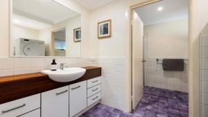 a white bathroom with a sink and a shower at Salty Seaside in New Brighton