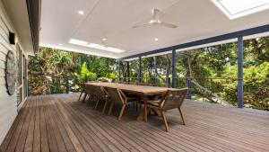 a wooden deck with a table and chairs on it at Salty Seaside in New Brighton