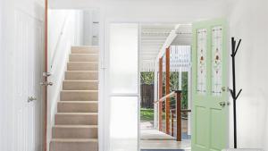 a hallway with a green door and stairs at Whalesong in New Brighton