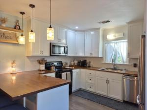a kitchen with white cabinets and a wooden counter top at Garden Clara in Yuba City