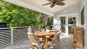 a porch with a wooden table and chairs and a ceiling fan at The Anchorage in New Brighton