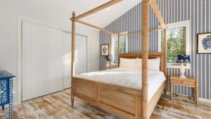 a bedroom with a canopy bed and a wooden floor at The Anchorage in New Brighton +9 photos