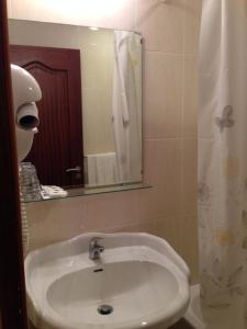 uma casa de banho com um lavatório e um espelho em Hotel Vale Verde em Furnas
