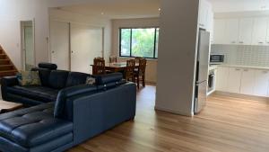 a living room with a couch and a kitchen at Hook Wine & Sinker in Brunswick Heads