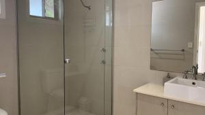 a bathroom with a glass shower and a sink at Hook Wine & Sinker in Brunswick Heads +4 photos