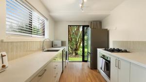 a kitchen with white counters and a stove top oven at Brunswick Palms 1 in Brunswick Heads