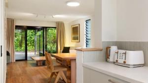 a kitchen with a table and a dining room at Brunswick Palms 1 in Brunswick Heads