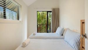 a bedroom with two beds and a window at Brunswick Palms 1 in Brunswick Heads