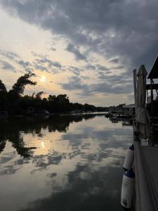 a boat is docked on a river at sunset at Vasilisa Luxury River House in Pančevo