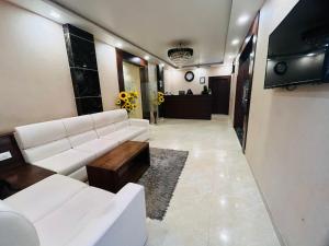 a living room with a white couch and a table at Sangam Hotel in Kiul