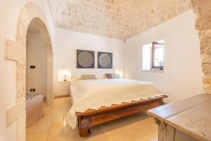 a bedroom with a bed and a stone wall at Trulli Oasis in Noci