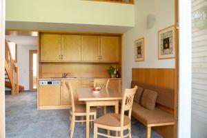 a kitchen with a table and chairs in a room at Aparthotel Schindlhaus/Alpin in Söll