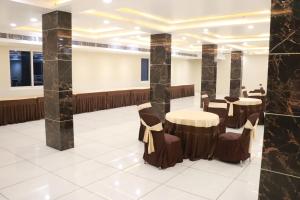 a lobby with tables and chairs in a building at Sangam Hotel in Kiul
