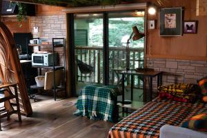 a living room with a bed and a balcony at MOSAIC hinohara in Motojuku