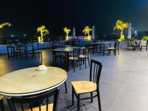 a row of tables and chairs on a roof at night at Sangam Hotel in Kiul