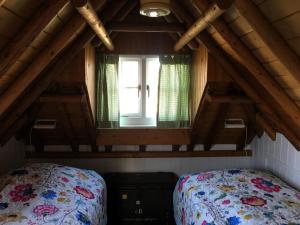 a bedroom with a bed and a window in a attic at Boerderijte De Lytse Formerum in Formerum