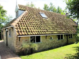 an old brick house with a shingled roof at Boerderijte De Lytse Formerum in Formerum