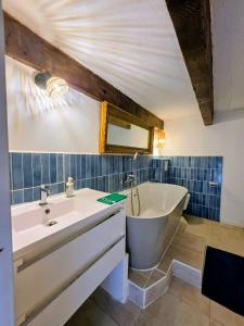 a bathroom with a sink and a tub next to a sink at Lavande in Beaumont-de-Pertuis