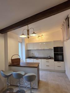 a kitchen with white cabinets and bar stools at Lavande in Beaumont-de-Pertuis +9 photos