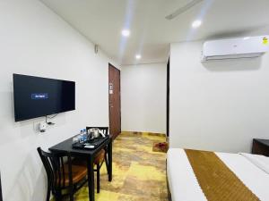 pokój z łóżkiem, stołem i telewizorem w obiekcie Hotel Vasundhara Villa - Greater Kailash w Nowym Delhi