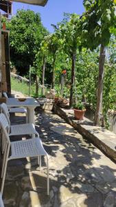 a group of white tables and chairs on a patio at Studio in Elatochori - O Elato in Elatochori