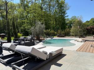 a swimming pool with chaise lounge chairs and a swimming pool at Villa golf merignies in Mérignies