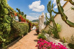 a garden with flowers and cactuses and a pathway at Nifu nifa in Antigua Guatemala