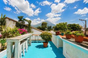 a view from the balcony of a house with blue floors and plants at Nifu nifa in Antigua Guatemala