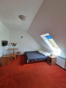 a bedroom with a bed and a window in a attic at Willa Anna Kluszkowce in Kluszkowce +49 photos