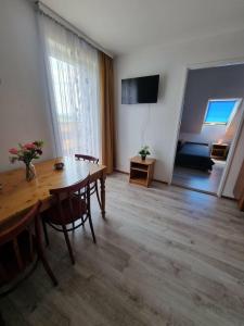 a living room with a wooden table and a dining room at Willa Anna Kluszkowce in Kluszkowce