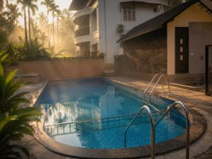 a swimming pool in front of a house at Amara Lux Rivage wynad in Vythiri