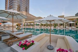 a swimming pool with chairs and umbrellas in a hotel at Boulevard Residence Suite, 3 in Tashkent