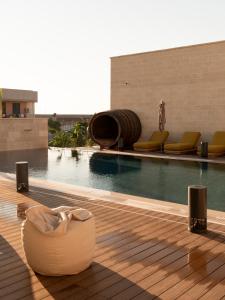 a swimming pool with a couch next to a building at Dimora Mennuti in Monteparano