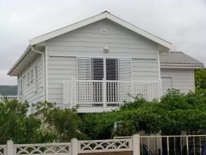 a white house with a fence in front of it at ZEN Tree bed & breakfast in Paarl