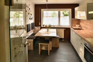 a kitchen with a table and two windows at Ferienwohnung Landsknecht in Volkach