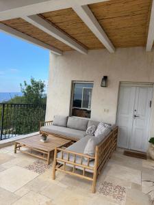 a patio with a couch and a coffee table at Benichuta in Mitzpe Hila