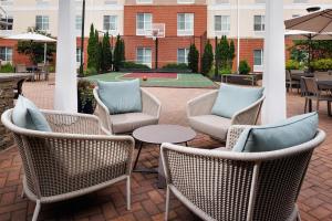 a patio with wicker chairs and a table with pillows at Homewood Suites New Brighton in Roseville
