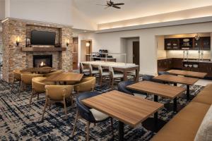 a restaurant with tables and chairs and a fireplace at Homewood Suites New Brighton in Roseville
