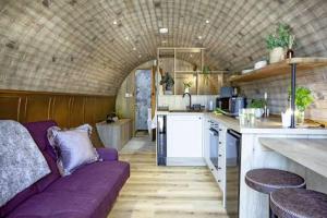 a living room with a purple couch in a kitchen at Nook in Binegar