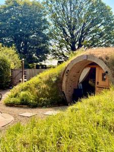 a small building in the middle of a grassy hill at Nook in Binegar