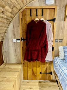a room with a wooden door with a red sweater at Nook in Binegar