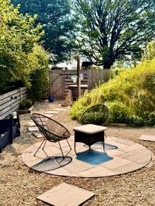 two chairs and a table in a garden at Nook in Binegar