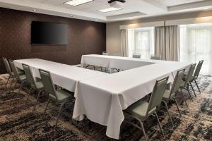 a conference room with tables and chairs and a flat screen tv at Homewood Suites New Brighton in Roseville +49 photos