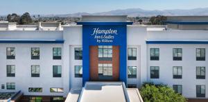 a large white building with a blue sign on it at Hampton Inn & Suites Salinas in Salinas