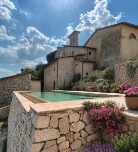 a house with a swimming pool in front of a building at Claustrum di Colforcella in Cascia