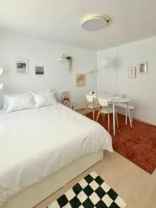a white bedroom with a bed and a table at Aralla Stay-고척돔 15분 거리 #홍대 이태원 영등포 여의도 대중교통 30분 내 도착 #목동역 도보 15분 #목동역 차로 5분 in Seoul
