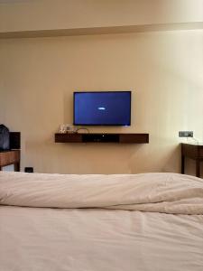 a bedroom with a bed and a tv on a wall at Jj Internatinals Group in Bhopal